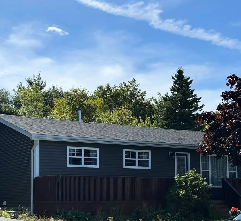 Blue-grey bungalow with a new dark shingled roof